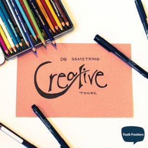 piece of paper surrounded by pens and colored pencils that says do something creative today