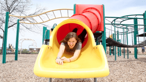 Hannah Merlo going down head first down a slide on a playground