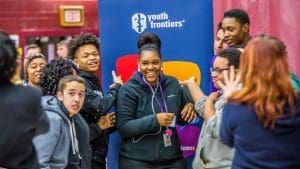 YFLC Group of students laughing together in front of a youth frontiers banner