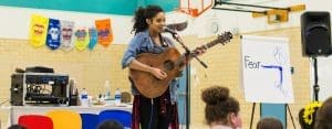 Retreat Facilitator, Dahlia, singing and playing her guitar for seventh-grade students.