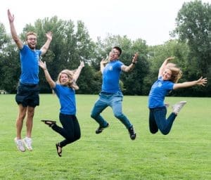 four members of Y-corps jumping up in the air smiling